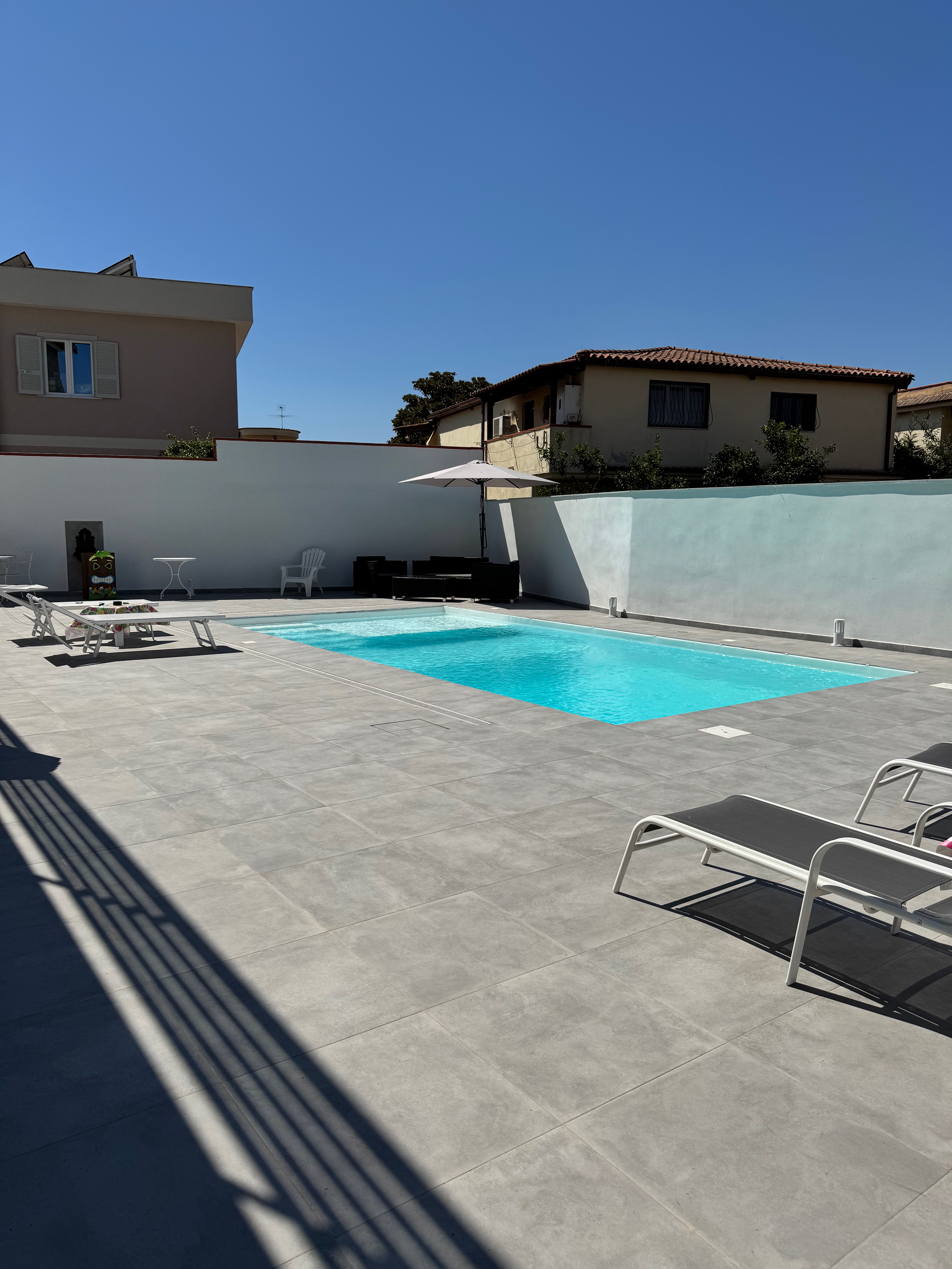 Piscina con solarium e lettini prendisole