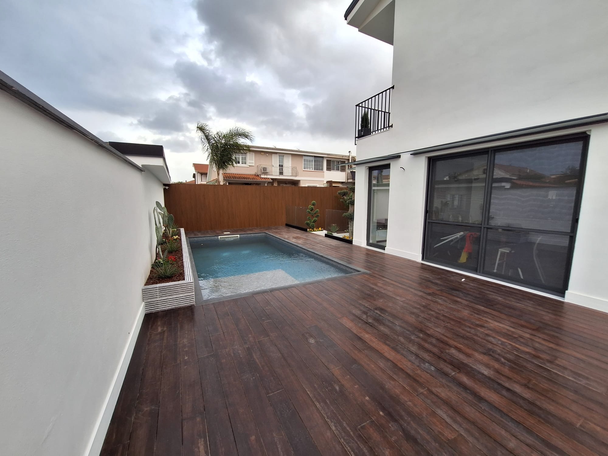 Piscina con deck in legno e ampie vetrate